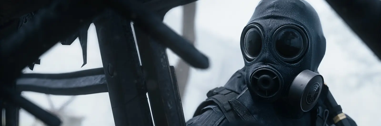 An Operator in a black gas mask and hood in the snow in MW4 DMZ