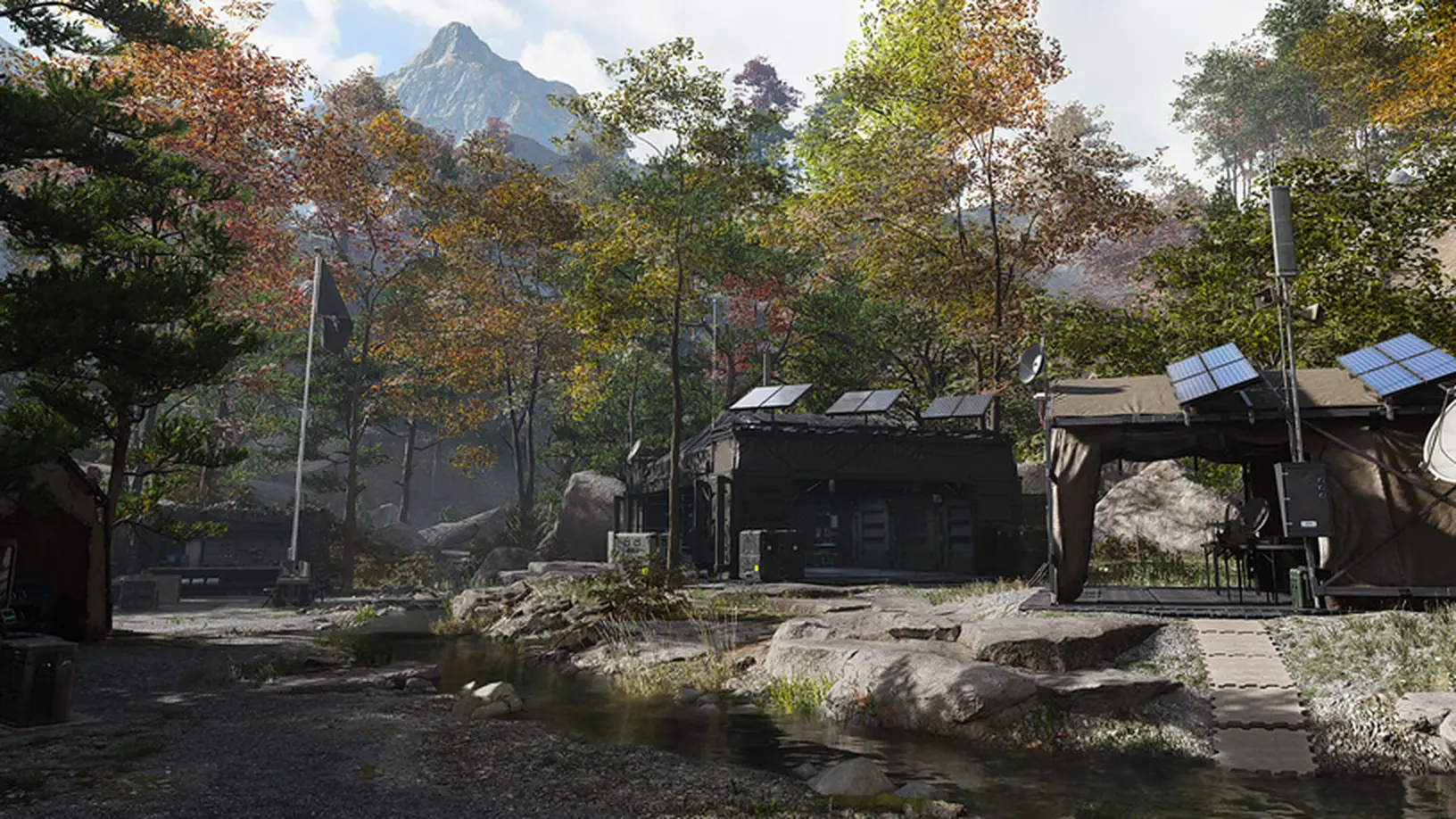 The Forward Operating Base in MW4 DMZ: tents with solar panels and a satellite dish in an autumn forest clearing below a mountain