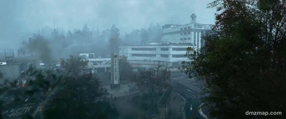A foggy town centre in Hajin, MW4 DMZ: a plaza with a tall sign, empty roads and a hospital block with a green cross behind