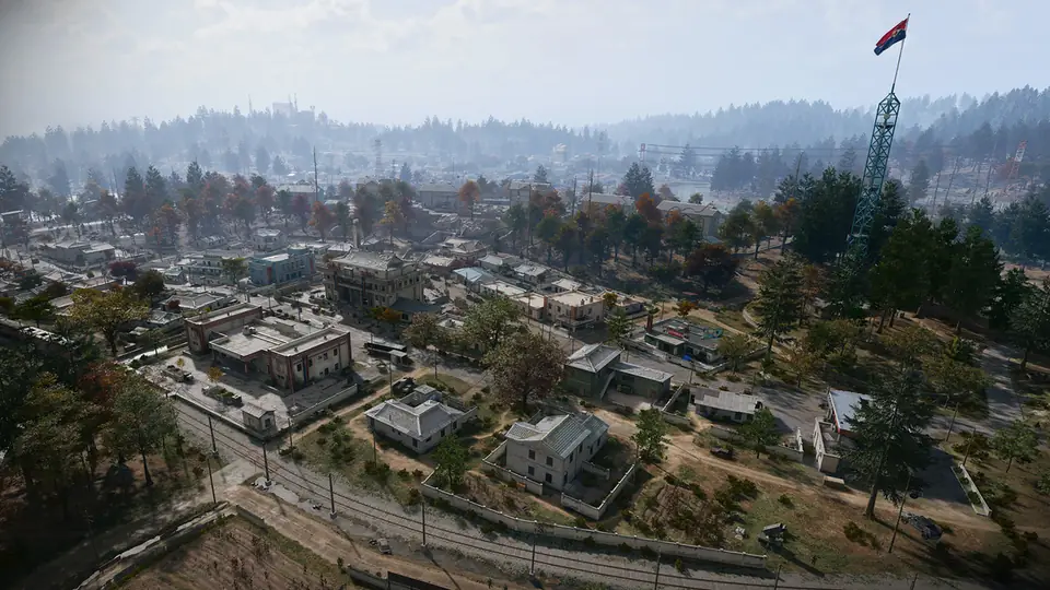 Deadtown from above in MW4 DMZ: rows of low houses, a railway and a tall red flag mast